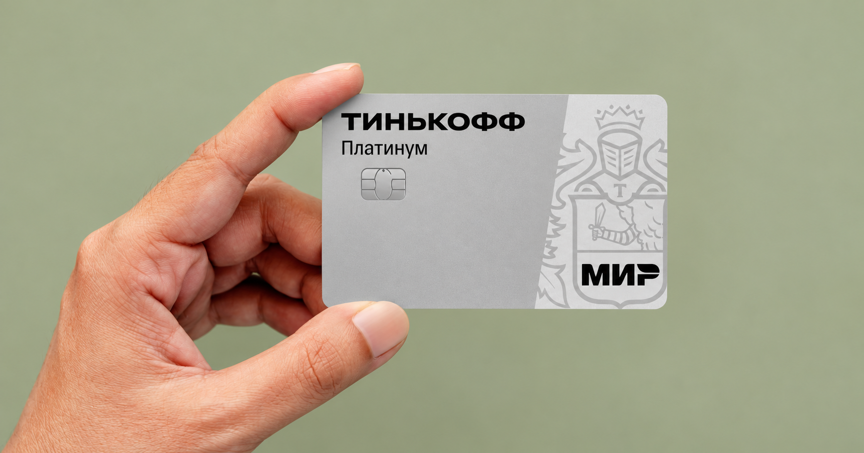 Рука держит карту Тинькофф Платинум на оливковом фоне